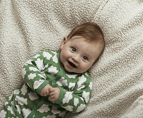 Image showing cute little baby playing with hands and smiling