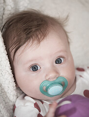 Image showing cute little baby playing with hands and smiling