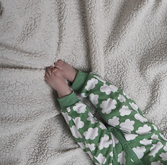 Image showing cute little baby playing with hands and smiling