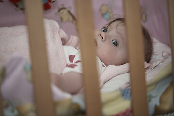 Image showing cute little baby playing with hands and smiling