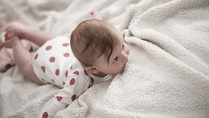 Image showing cute little baby playing with hands and smiling