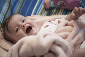 Image showing cute little baby playing with hands and smiling