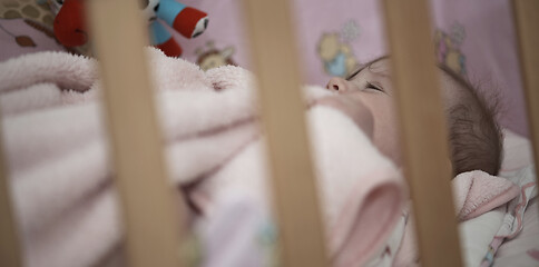 Image showing cute little baby playing with hands and smiling