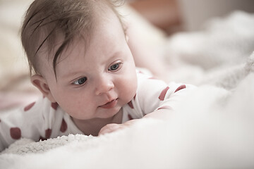 Image showing cute little baby playing with hands and smiling