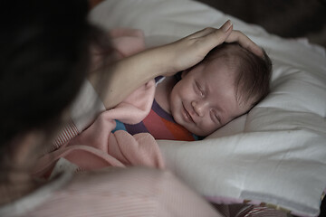 Image showing new born baby sleeping and in dreams smillling