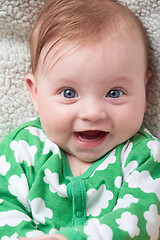 Image showing cute little baby playing with hands and smiling