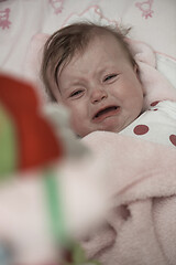 Image showing cute little baby playing with hands and smiling