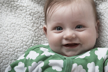 Image showing cute little baby playing with hands and smiling