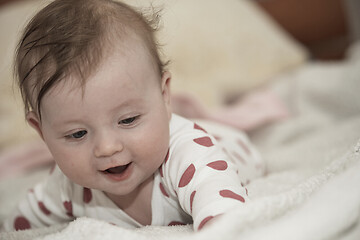 Image showing cute little baby playing with hands and smiling