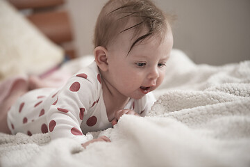 Image showing cute little baby playing with hands and smiling