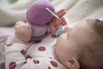 Image showing cute little baby playing with hands and smiling