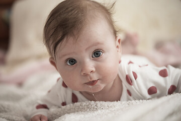 Image showing cute little baby playing with hands and smiling