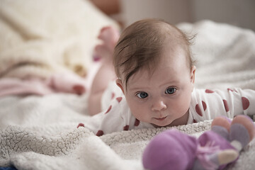 Image showing cute little baby playing with hands and smiling