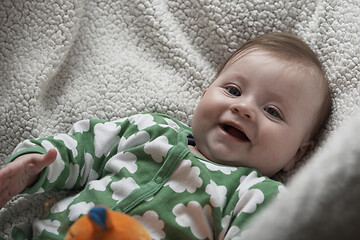 Image showing cute little baby playing with hands and smiling