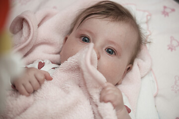 Image showing cute little baby playing with hands and smiling