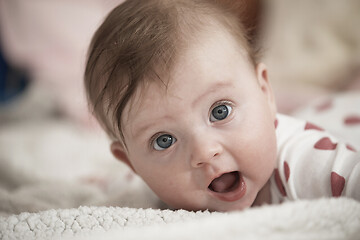 Image showing cute little baby playing with hands and smiling