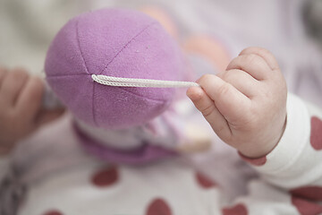 Image showing cute little baby playing with hands and smiling