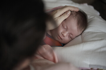 Image showing new born baby sleeping and in dreams smillling