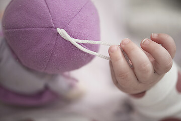 Image showing cute little baby playing with hands and smiling