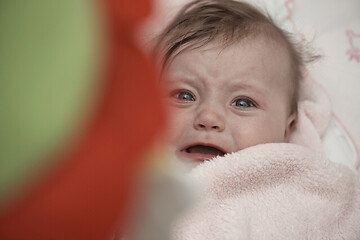 Image showing cute little baby playing with hands and smiling