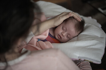 Image showing new born baby sleeping and in dreams smillling