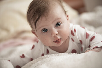 Image showing cute little baby playing with hands and smiling