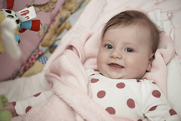 Image showing cute little baby playing with hands and smiling