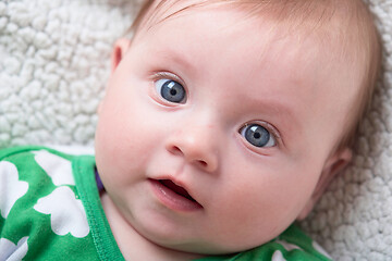 Image showing cute little baby playing with hands and smiling