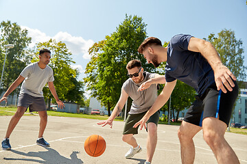 Image showing group of male friends playing street basketball