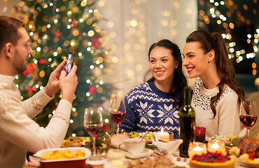 Image showing happy friends photographing at christmas dinner