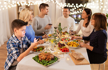 Image showing boy with smartphone at family dinner party