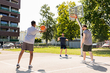 Image showing group of male friends playing street basketball