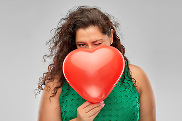 Image showing playful woman holding red heart shaped balloon