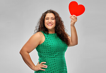 Image showing happy woman in green dress holding red heart