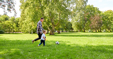 Image showing happy father and son playing soccer at summer park