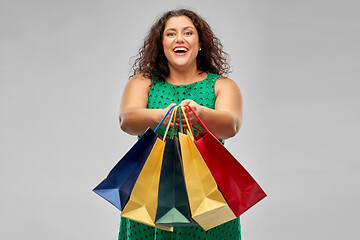 Image showing happy woman in green dress with shopping bags