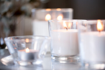 Image showing burning white fragrance candles on table