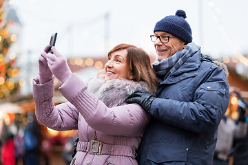 Image showing senior couple taking selfie at christmas market