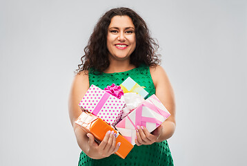 Image showing happy woman in green dress holding gift boxes