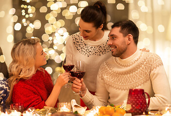 Image showing happy friends drinking red wine at christmas party