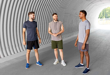 Image showing young sporty men or male friends talking in tunnel