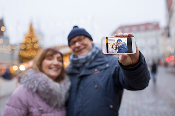 Image showing senior couple taking selfie at christmas market