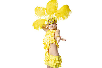 Image showing Beautiful young woman in carnival, stylish masquerade costume with feathers dancing on white studio background.