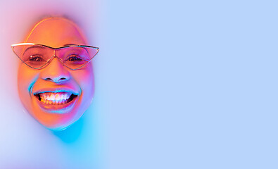 Image showing Beautiful female face in the milk bath with soft glowing in blue-pink neon light
