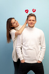 Image showing Beautiful couple in love on blue studio background. Valentine\'s Day, love and emotions concept