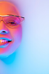 Image showing Beautiful female face in the milk bath with soft glowing in blue-pink neon light