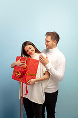 Image showing Beautiful couple in love on blue studio background. Valentine\'s Day, love and emotions concept