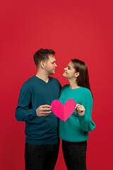 Image showing Beautiful couple in love on red studio background. Valentine\'s Day, love and emotions concept