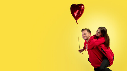 Image showing Beautiful couple in love on yellow studio background. Valentine\'s Day, love and emotions concept