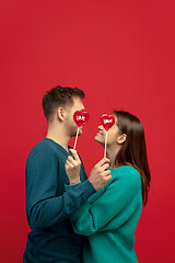 Image showing Beautiful couple in love on red studio background. Valentine\'s Day, love and emotions concept